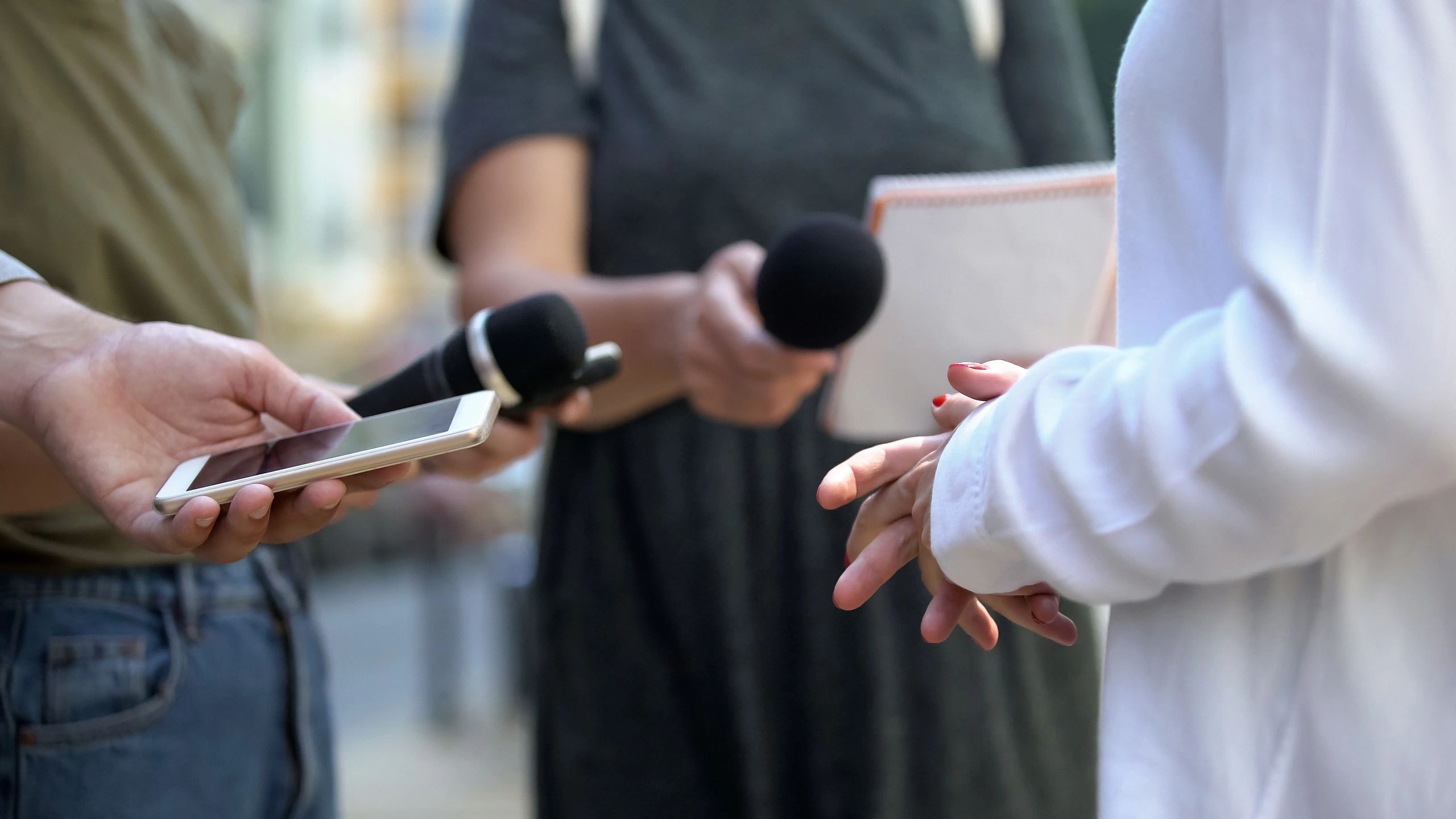 Woman gesticulating during interview with media, press conference