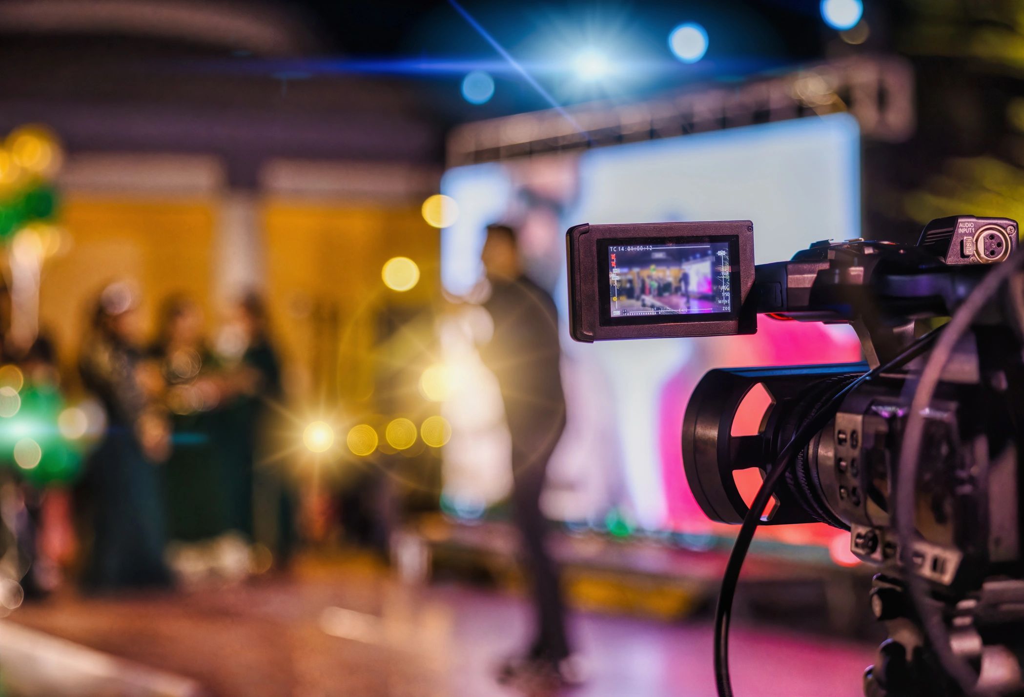 Camcorder filming a stage with lights